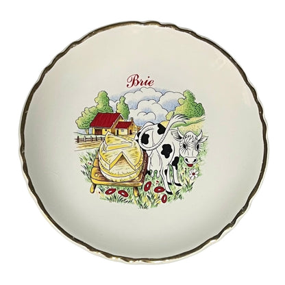 Decorative plate with a cow and Brie cheese illustration on a white background