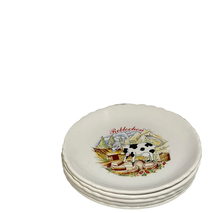 Set of ceramic plates with cow and landscape design on a white background