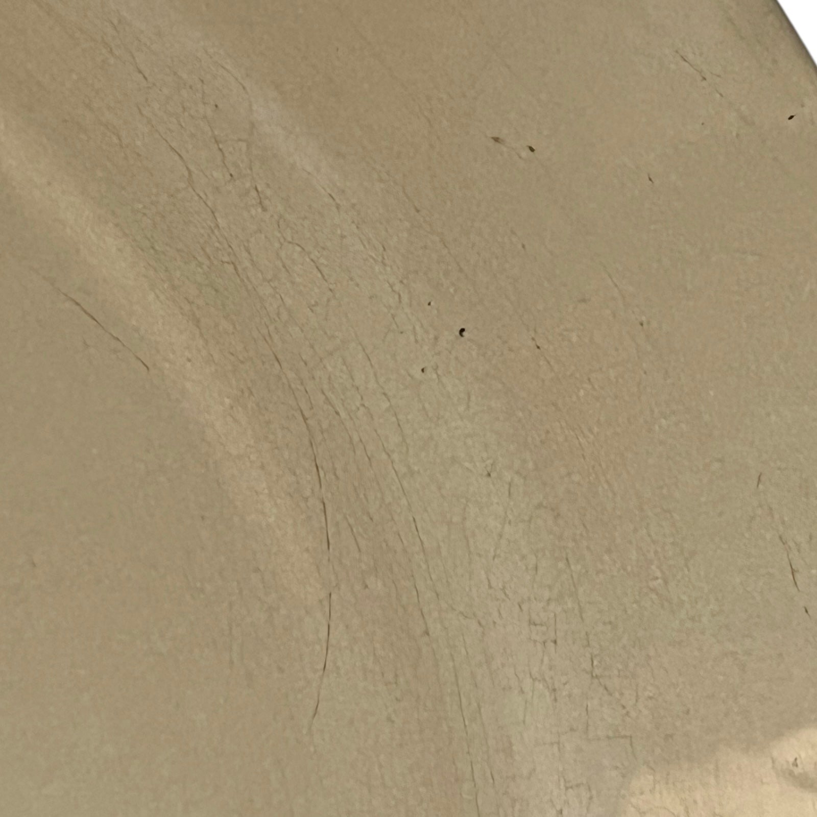Close up of Le Creuset dish with beige interior on a white background