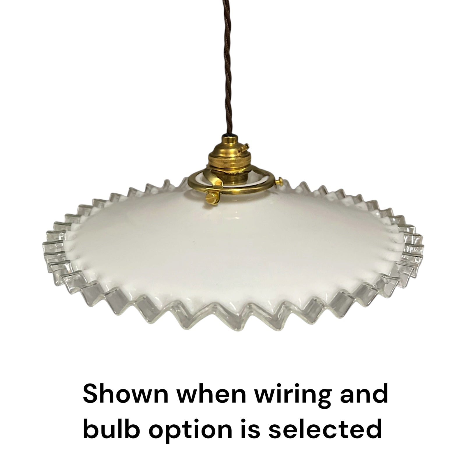 A vintage-style pendant light with a white frosted glass shade featuring a scalloped, wavy edge and a brass-colored metal socket, suspended by a dark cord. Text at the bottom reads 'Shown when wiring and bulb option is selected'.