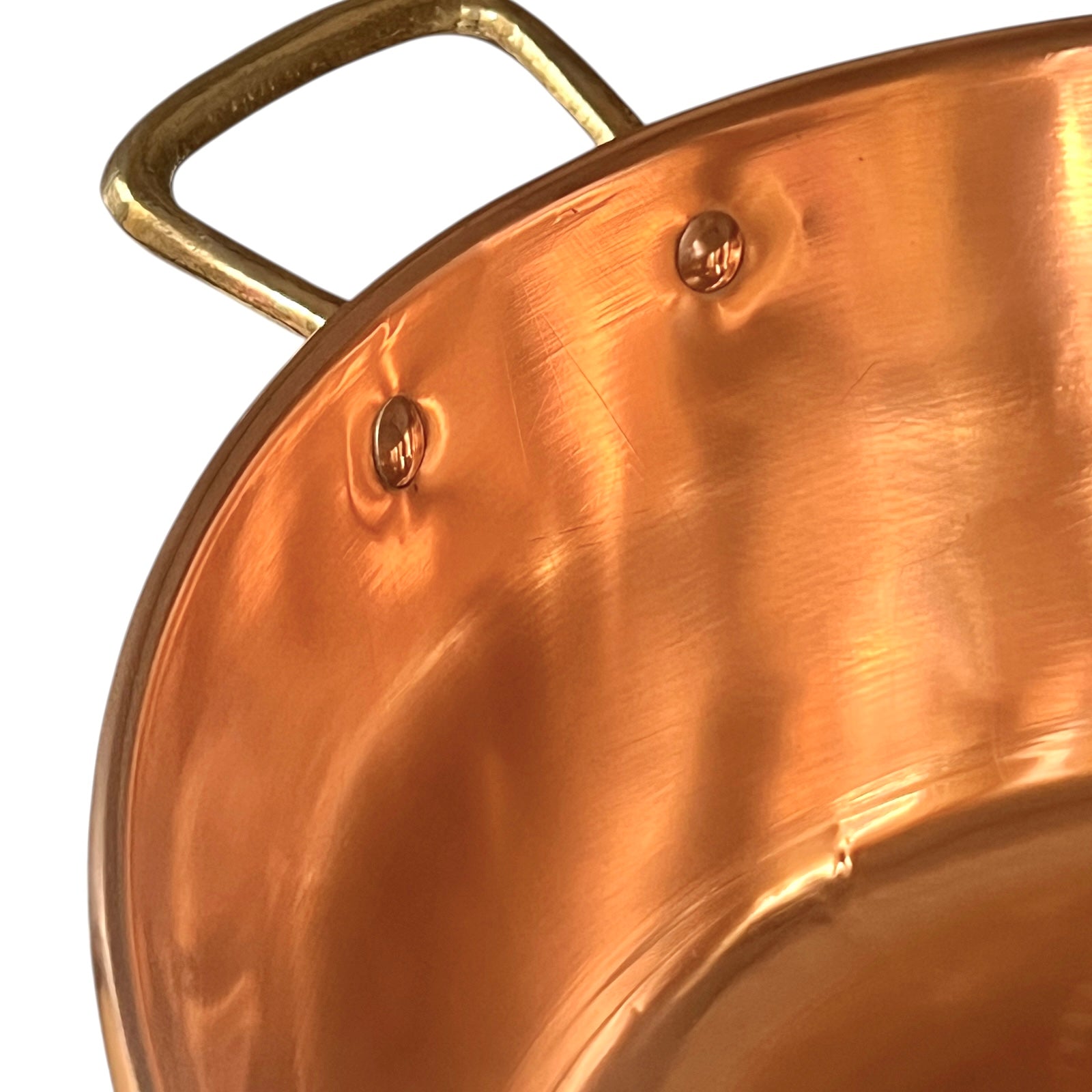 Close-up of a copper sink with a brass handle on a white background