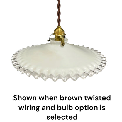A vintage-style pendant light with a white ribbed glass shade and a brass-colored socket, suspended by a brown twisted wire. Text at the bottom reads, 'Shown when brown twisted wiring and bulb option is selected' on a plain white background.