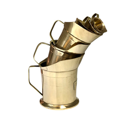 Stack of brass measuring cups on a white background