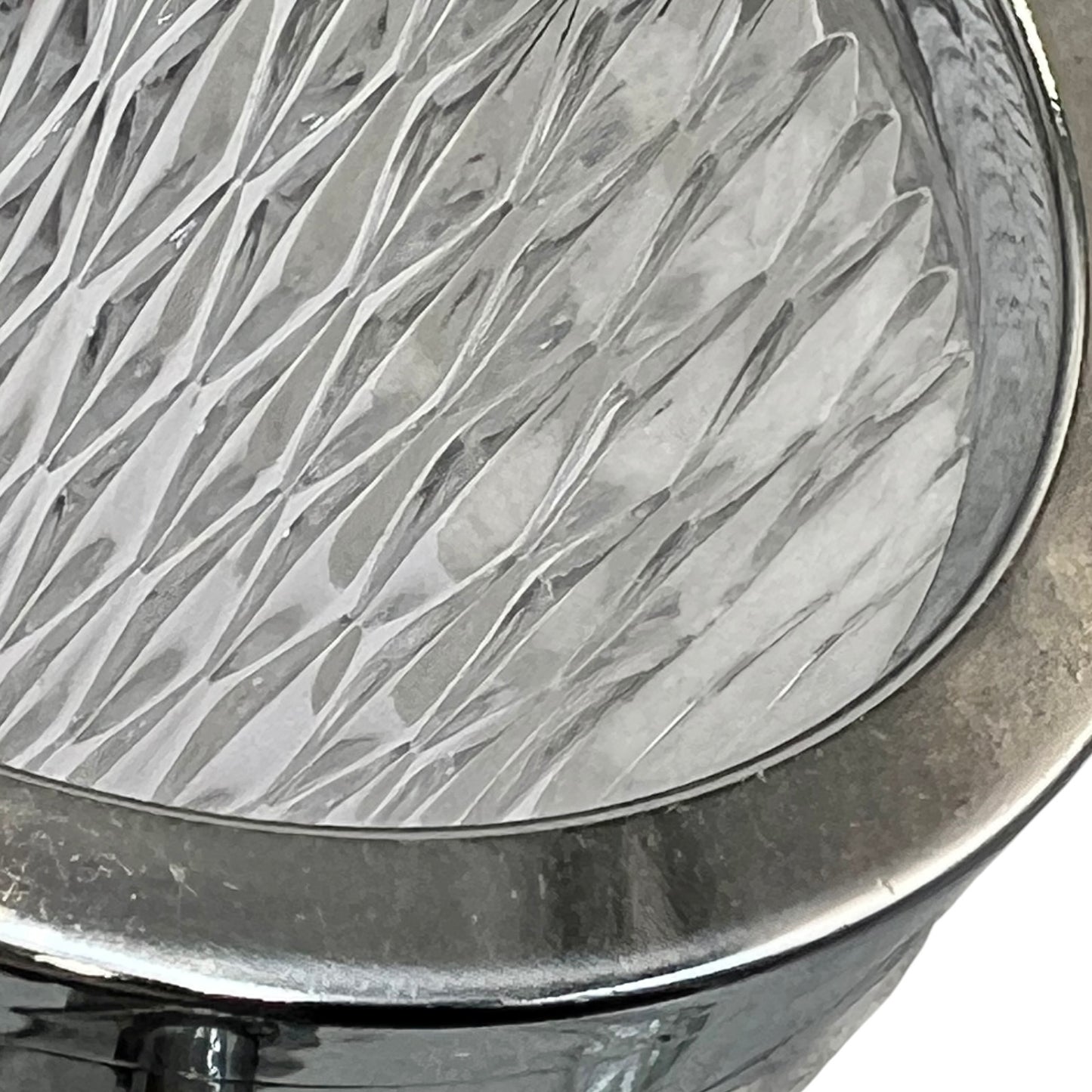 Close up of a French vintage glass ice bucket with a silver coloured collar and a handle on a white background 