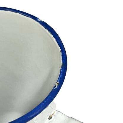 Close-up of a white enamel jug showing the interior and a blue rim on a white background.