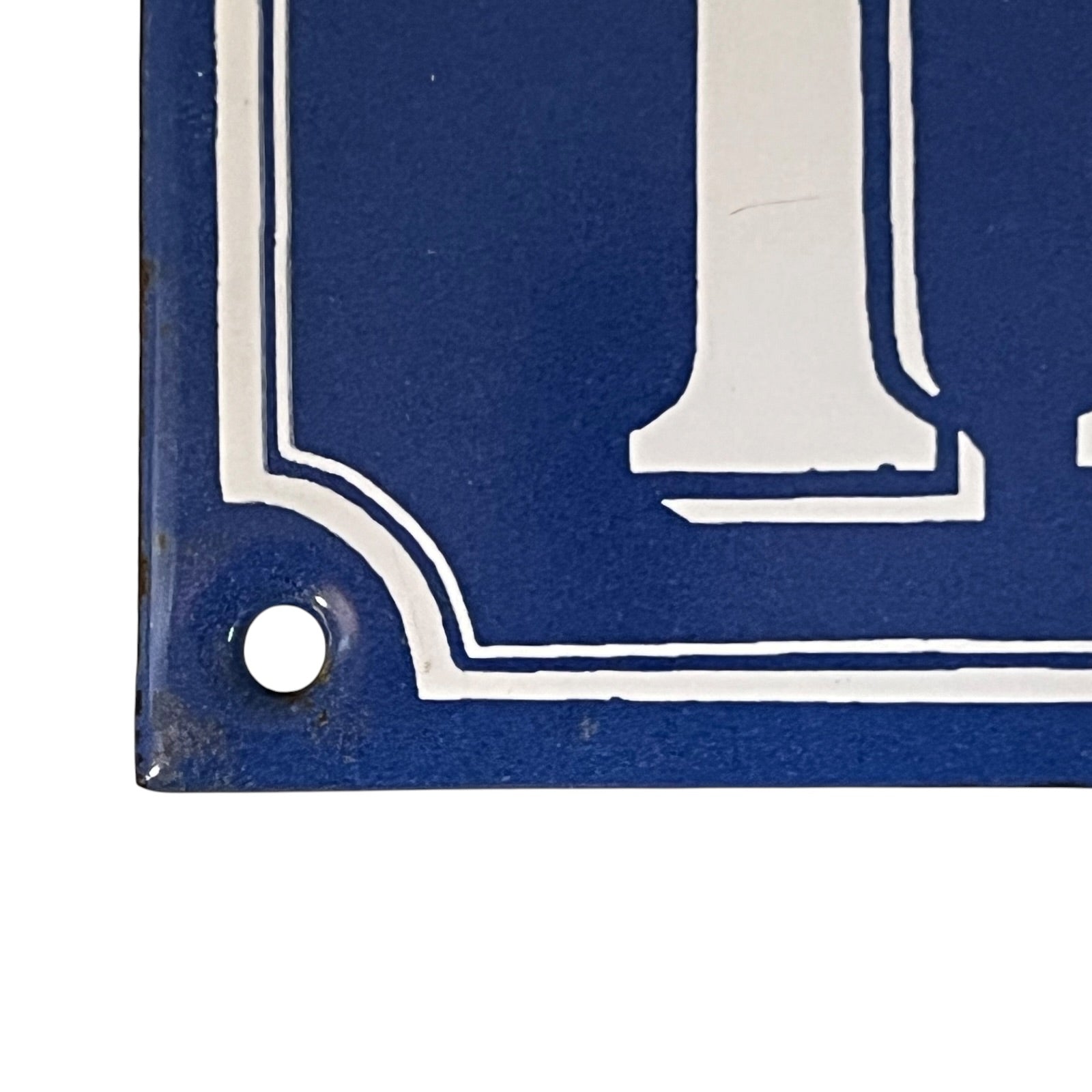 Close-up of a blue sign with a white numbers on a white background
