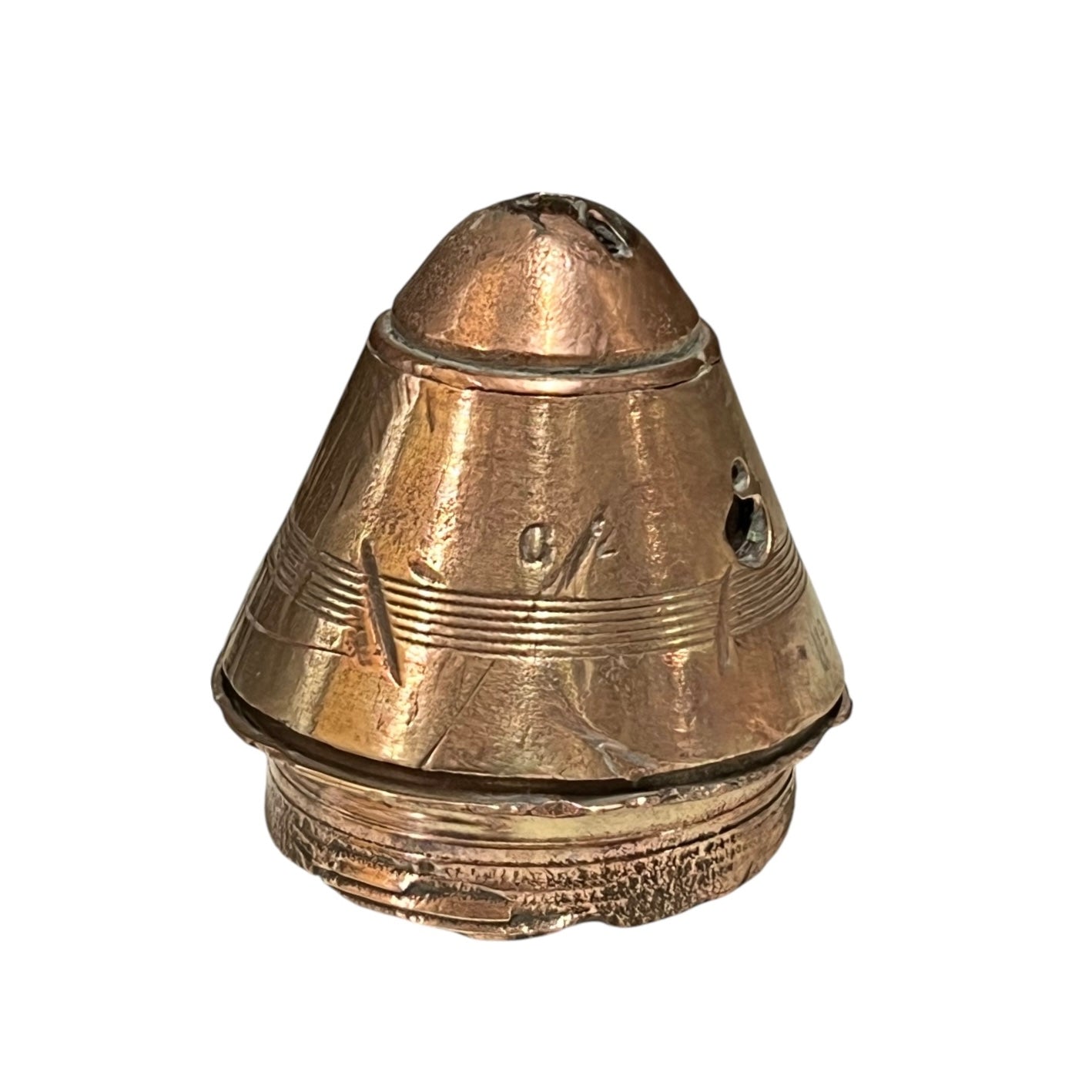 WW1 brass fuse paperweight with markings from use on a white background