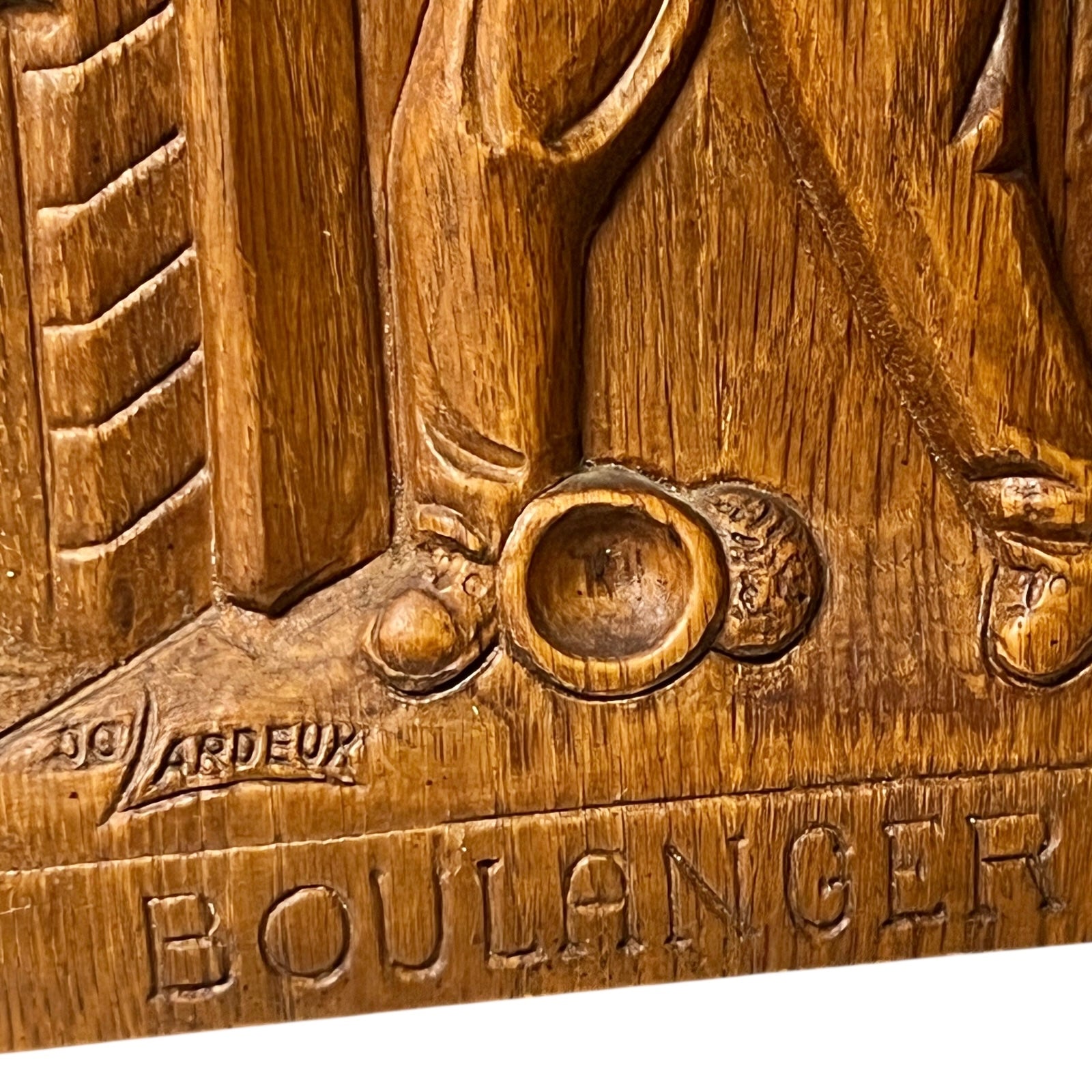 J.C. Lardeux signature on a wooden painting  titled Boulanger on a white background