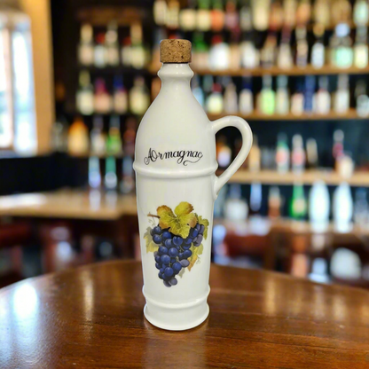 Decorative Armagnac bottle with grapes on a wooden table in a bar setting