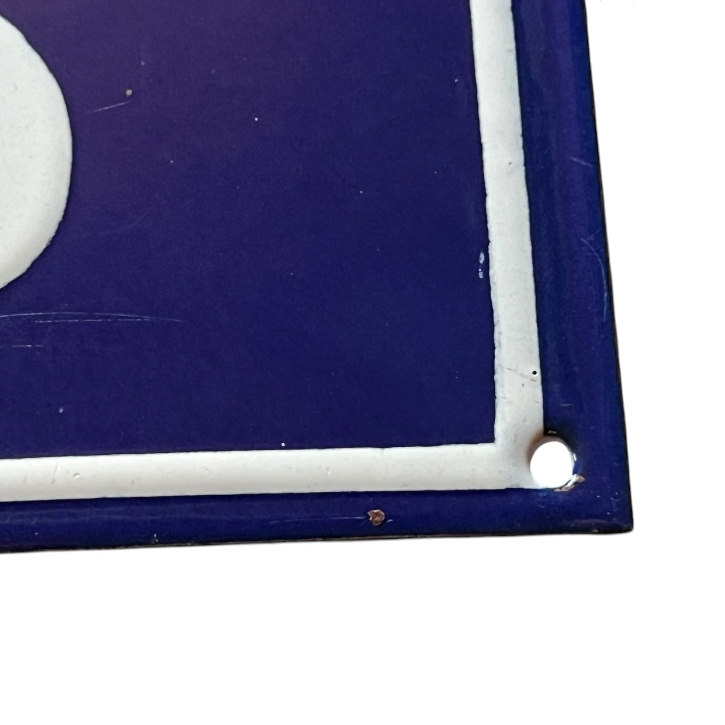 Close-up of a blue and white rectangular object with rounded corners on a white background