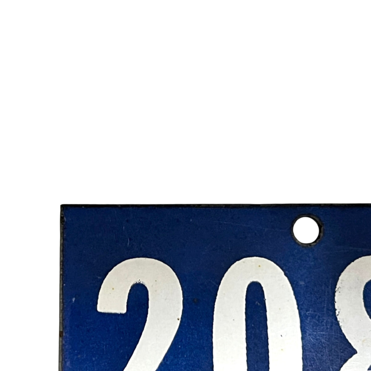 Close-up of a blue rectangular plaque or sign with large white numerals '208' and a small round hole near the top right, shown against a white background.