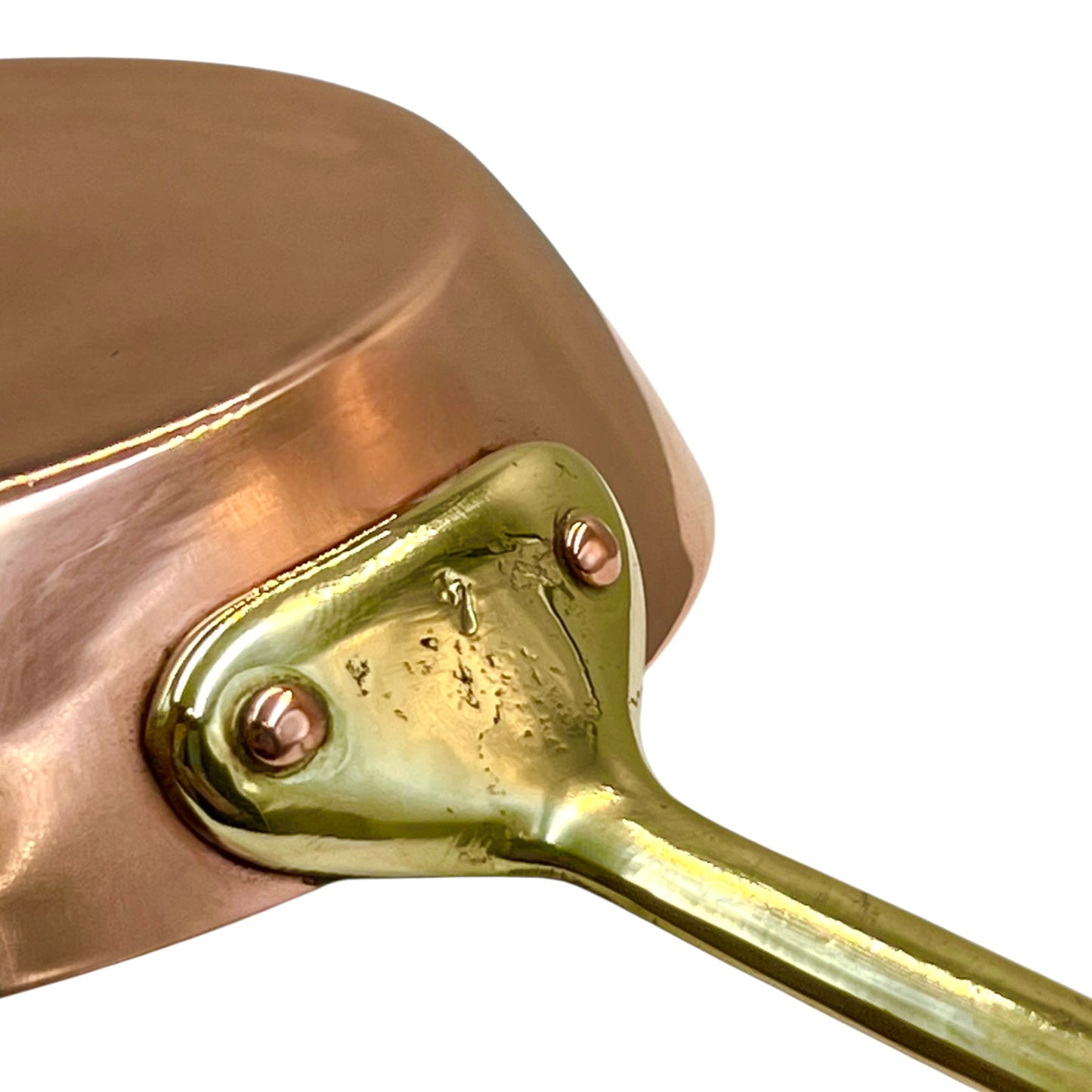 Close-up of a copper saucepan with a brass handle on a white background