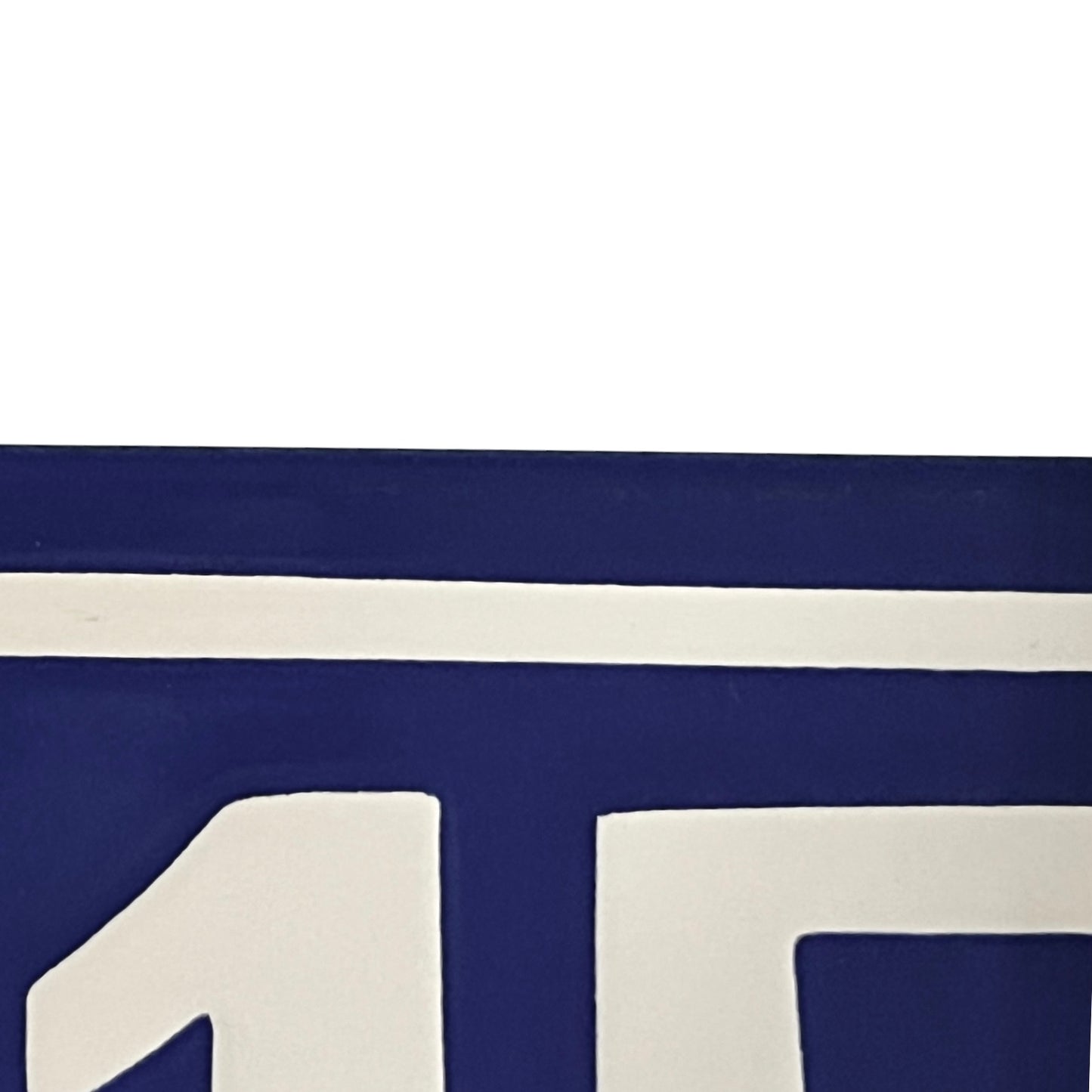A close-up of a navy blue and white sign showing bold geometric shapes and a horizontal stripe.