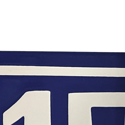 A close-up of a navy blue and white sign showing bold geometric shapes and a horizontal stripe.