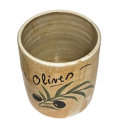 A rustic ceramic olive oil dispenser or cup with a beige stoneware finish, featuring a painted green olive branch with black olives and the word 'Olive' in black script.