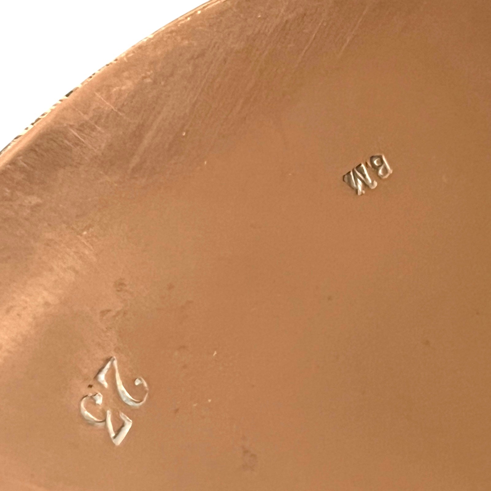 Close up of authentic vintage French copper pan lid showing the number 23 and a pair of initials  on a white background