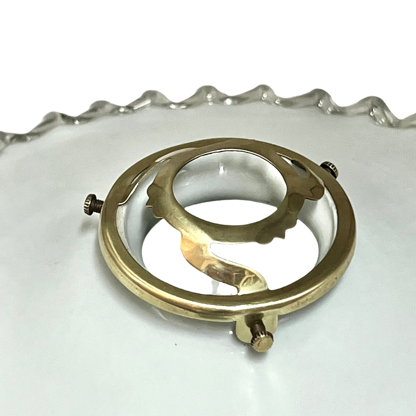 Close-up of a brass light clamp on a white background