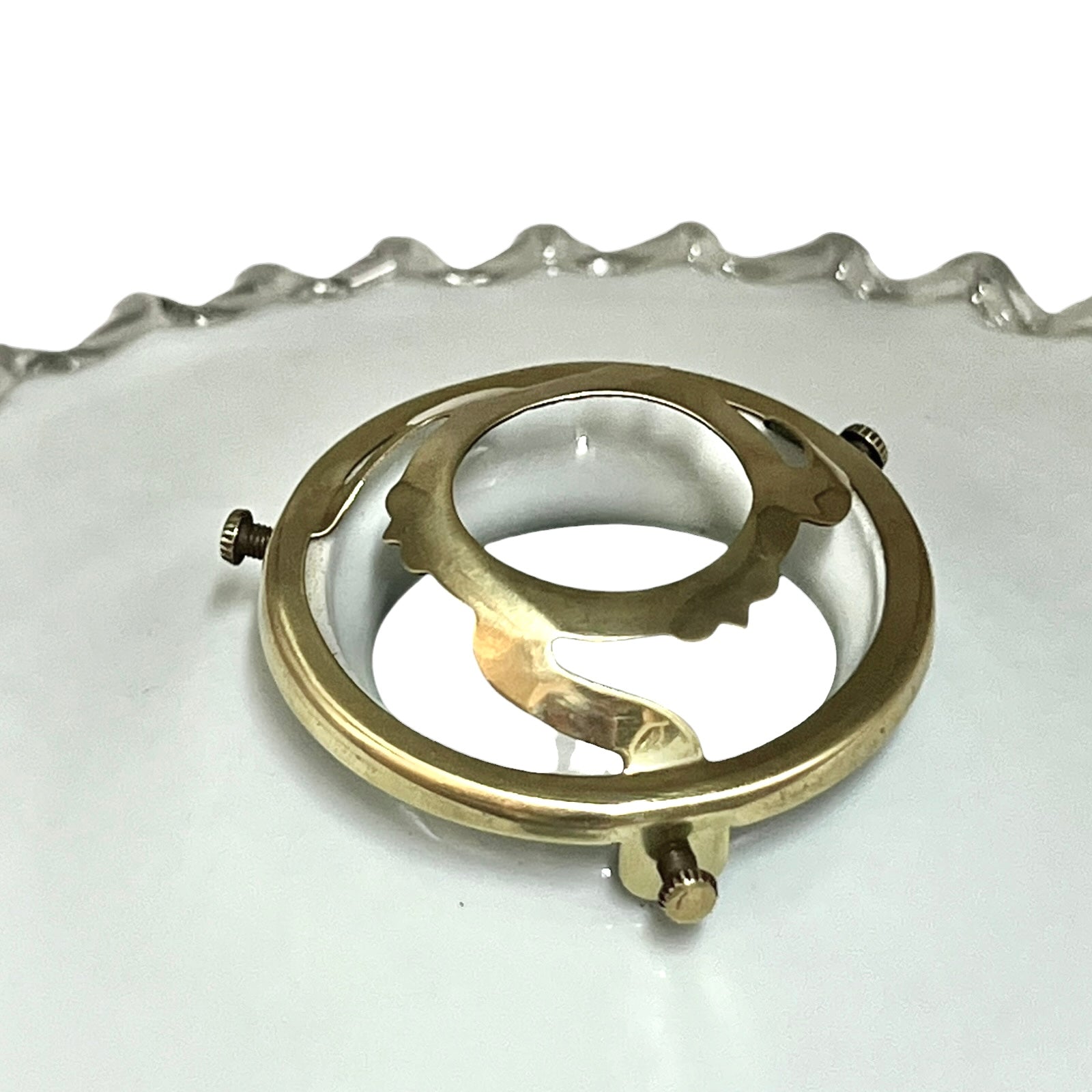 Close-up of a brass light clamp on a white background