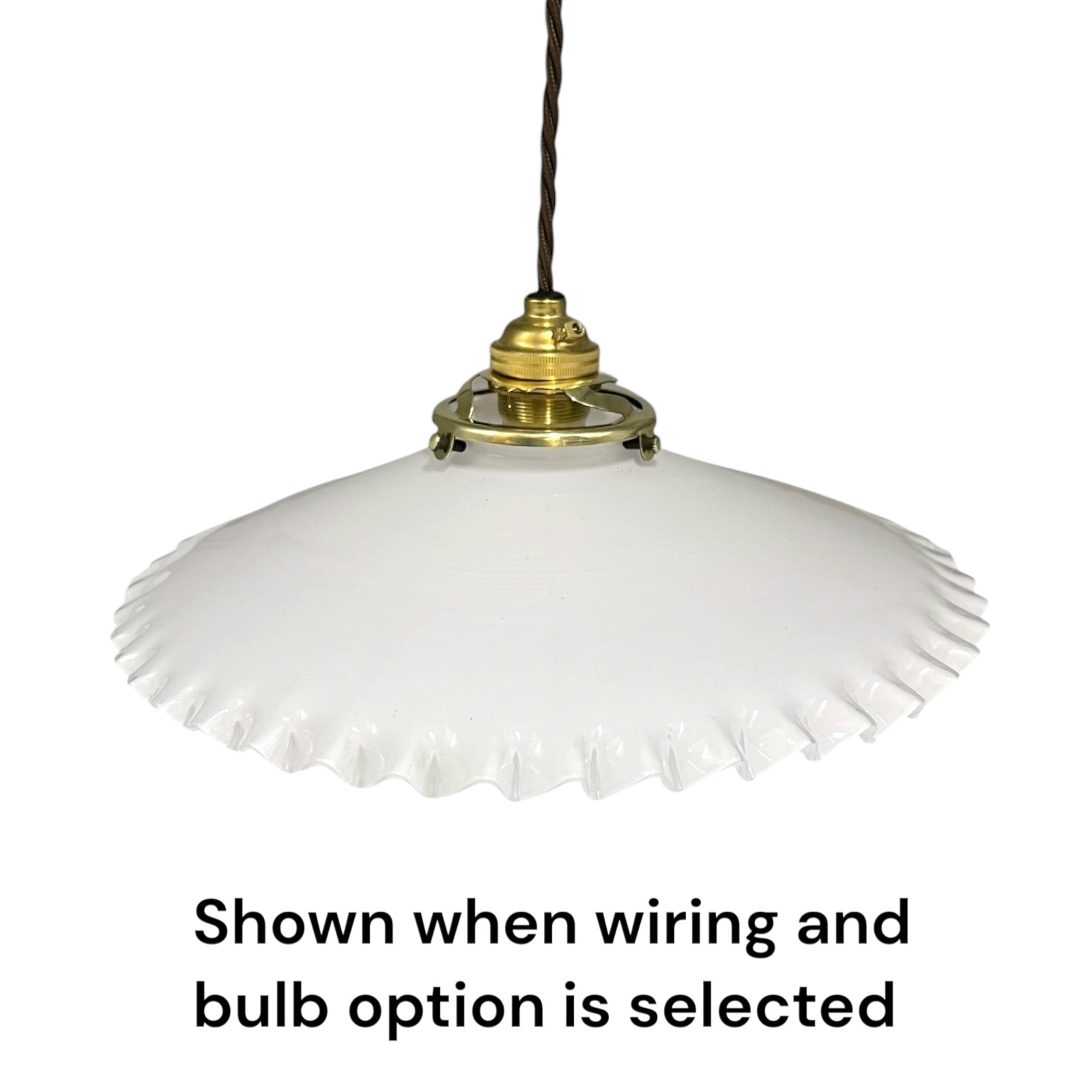 A white glass pendant light with a flared, scalloped rim and a brass-colored metal fixture, suspended by a dark cord. Text at the bottom reads, 'Shown when wiring and bulb option is selected'.