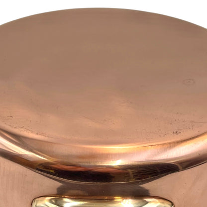 Small copper frying pan with a brass handle and tin lining on a white background