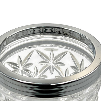 Clear French cut glass ice bucket with textured design and metal handle on a white background