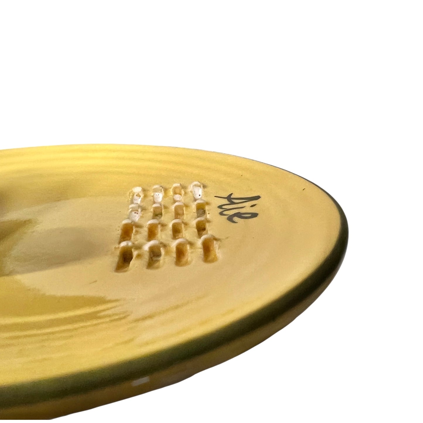A yellow plate featuring a green pepper and the French word for garlic, “Ail,” designed for grating garlic and perfect for a French farmhouse-style kitchen, set against a white background.