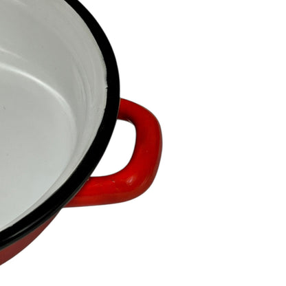 Close-up of a red enamel skillet on a white background