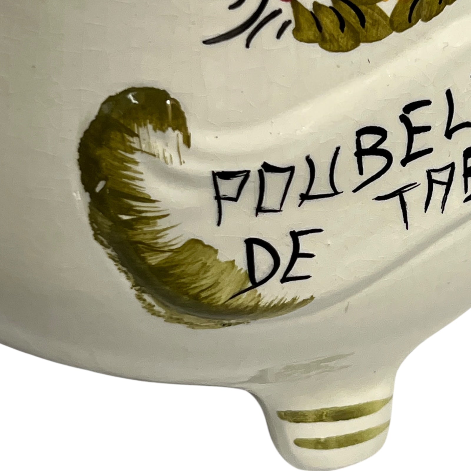 Ceramic dish with green leaf design and text on a white background