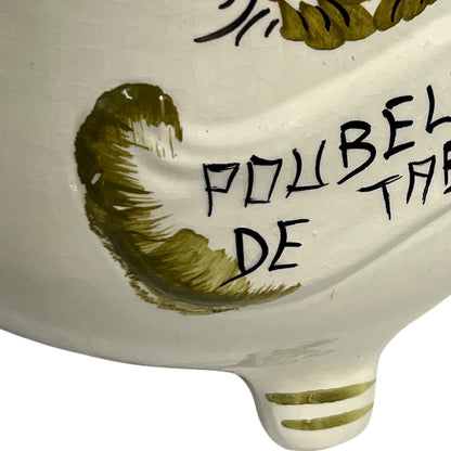 Ceramic dish with green leaf design and text on a white background