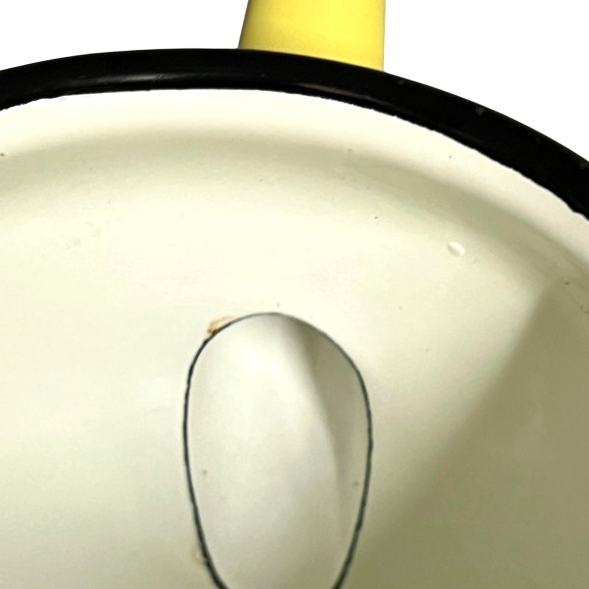 Close-up of a white enamel pot or pan showing the interior, a black rim, and a yellow handle at the top against a white background.