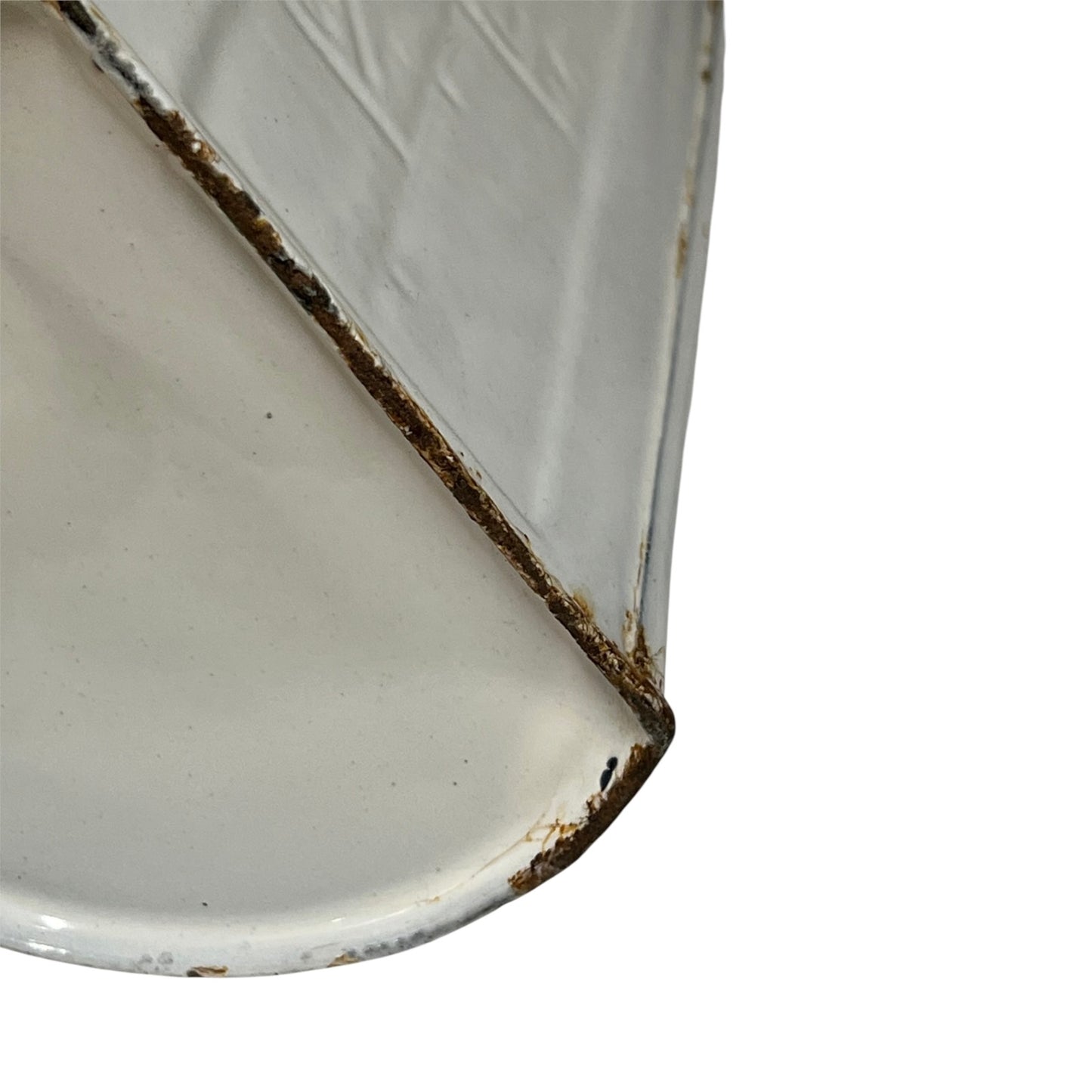 Close-up of a white enamel dish or tray corner showing a chipped edge with exposed rusted metal and a diagonal seam, isolated on a white background.