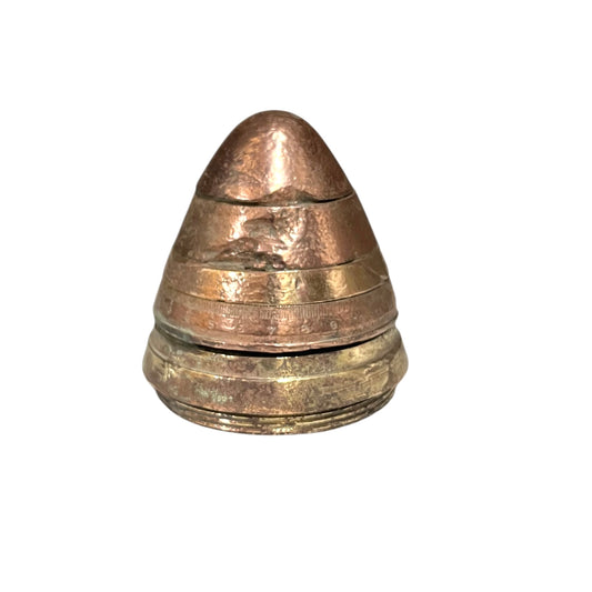 WW1 brass fuse now repurposed as a paperweight, with markings for identification of wear, on a white background