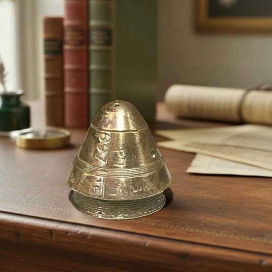 WW1 brass fuse paperweight on a desk in an office