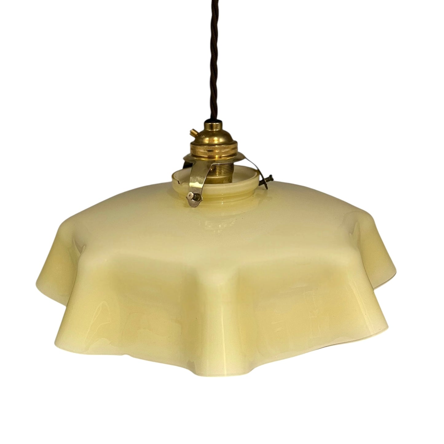 Vintage pendant light with dusky yellow glass shade and brass fixture on a white background