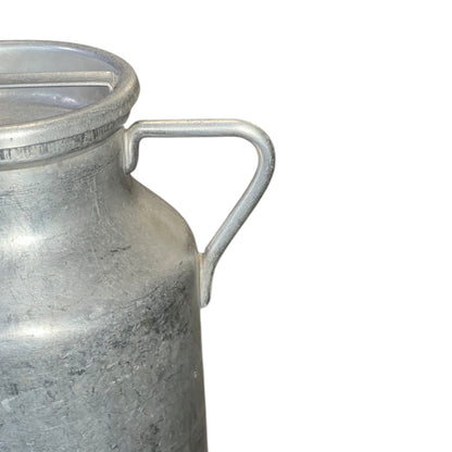 close up of metal milk churn on a white background