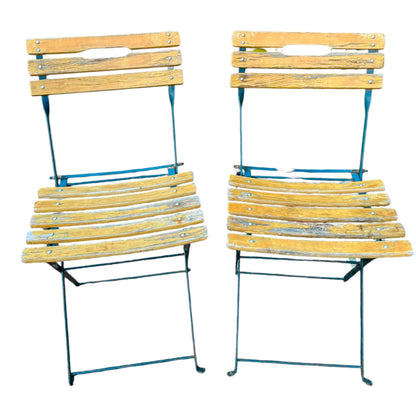 Two wooden folding chairs with metal frames on a white background
