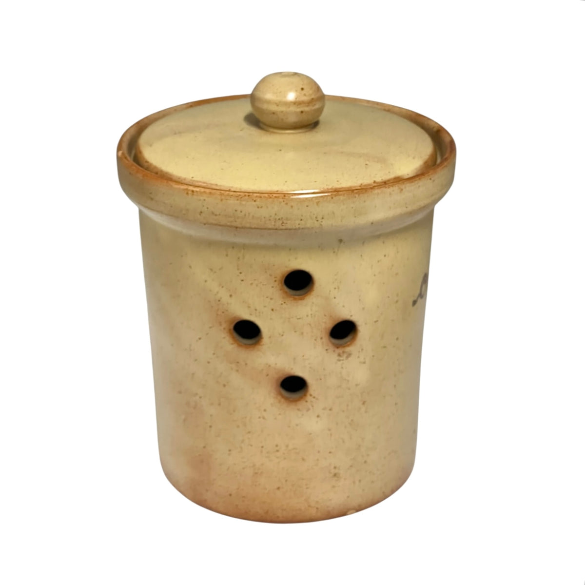 A handmade ceramic storage jar with a matching lid, featuring a speckled beige and cream glaze with a rustic brown rim and four ventilation holes on the side.
