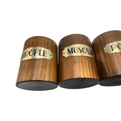 Three wooden containers with gold labels on a white background