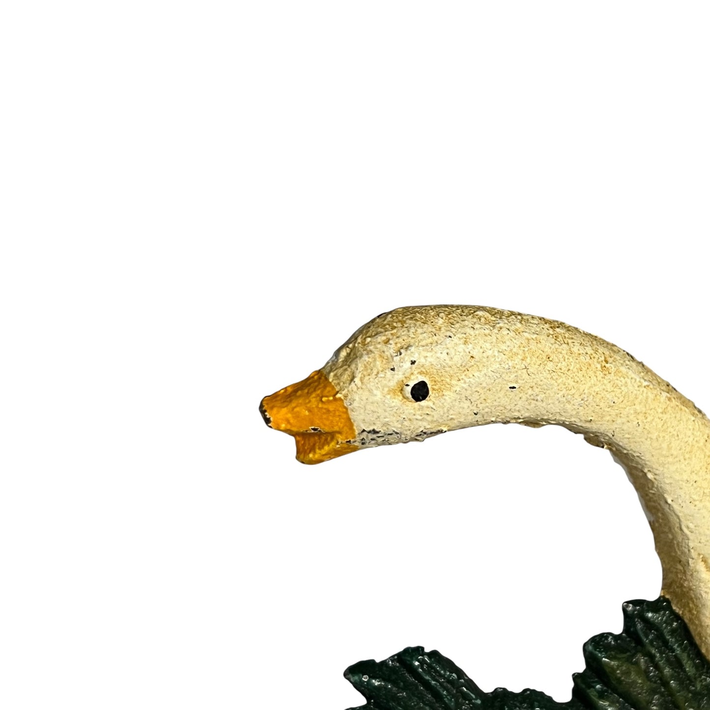 Close-up of a goose figurine head with a textured cream body, orange beak, and dark green base on a plain white background.