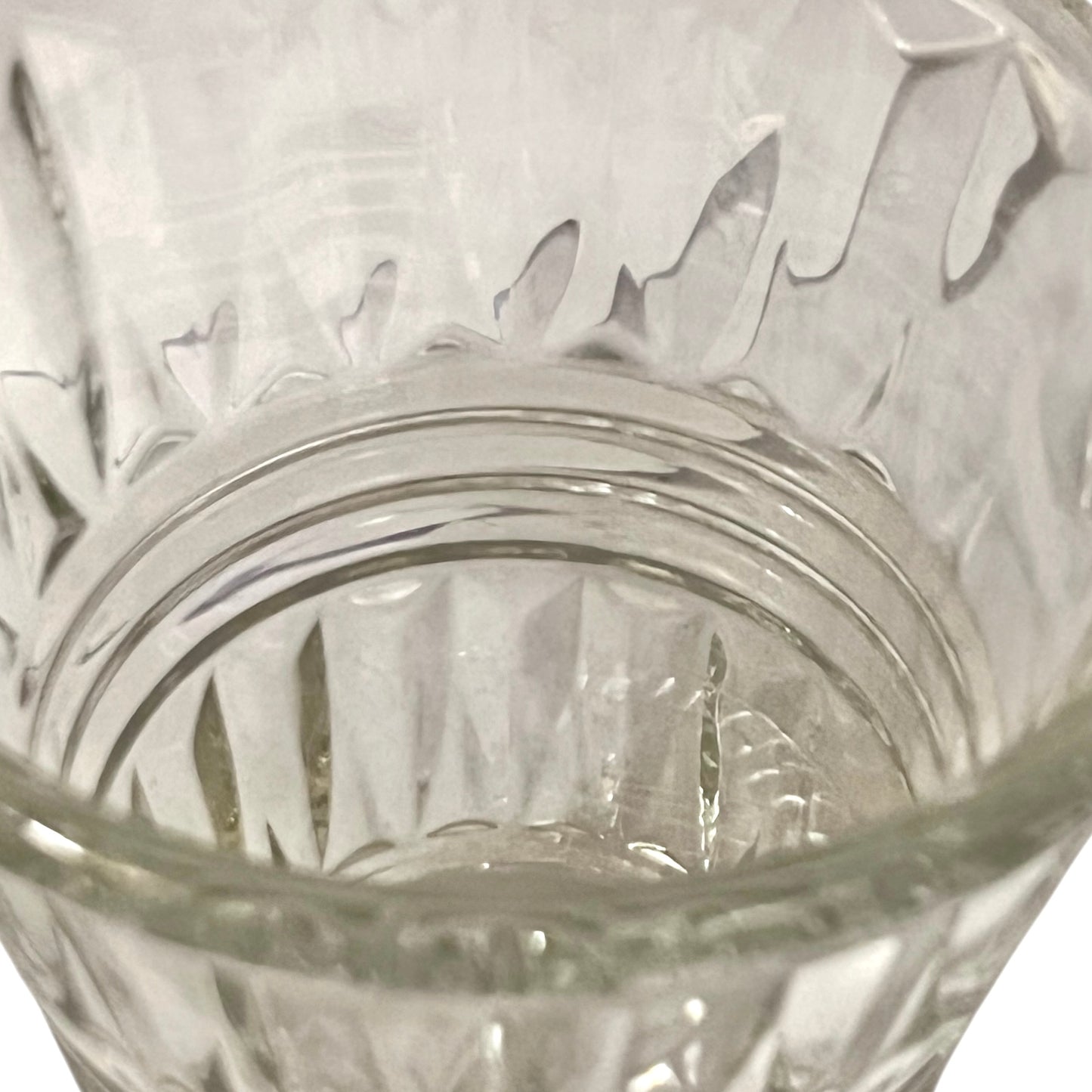 Close-up of a clear glass with intricate patterns on a white background