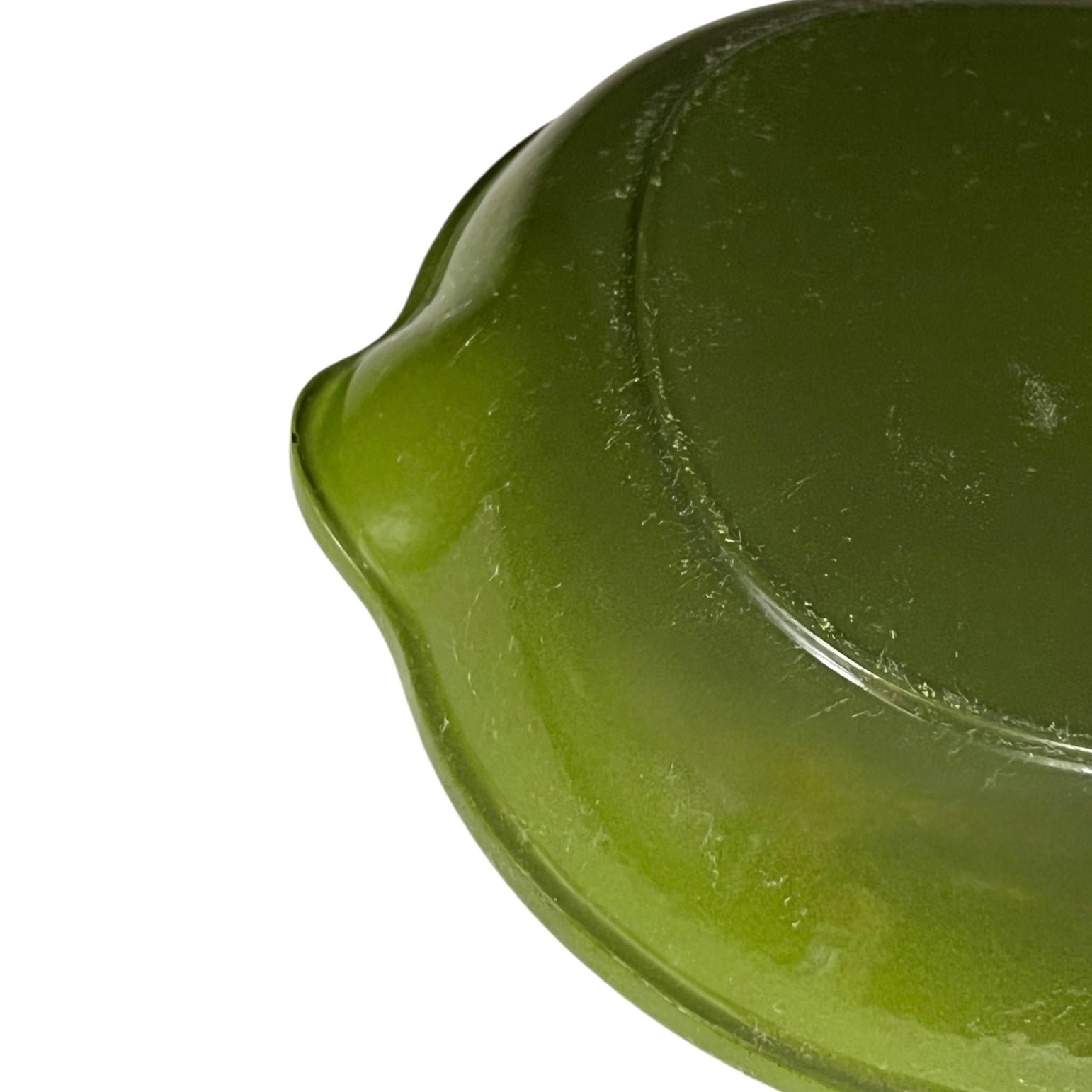 Close-up of a green Le Creuset cast iron skillet on a white background 