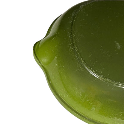 Close-up of a green Le Creuset cast iron skillet on a white background 