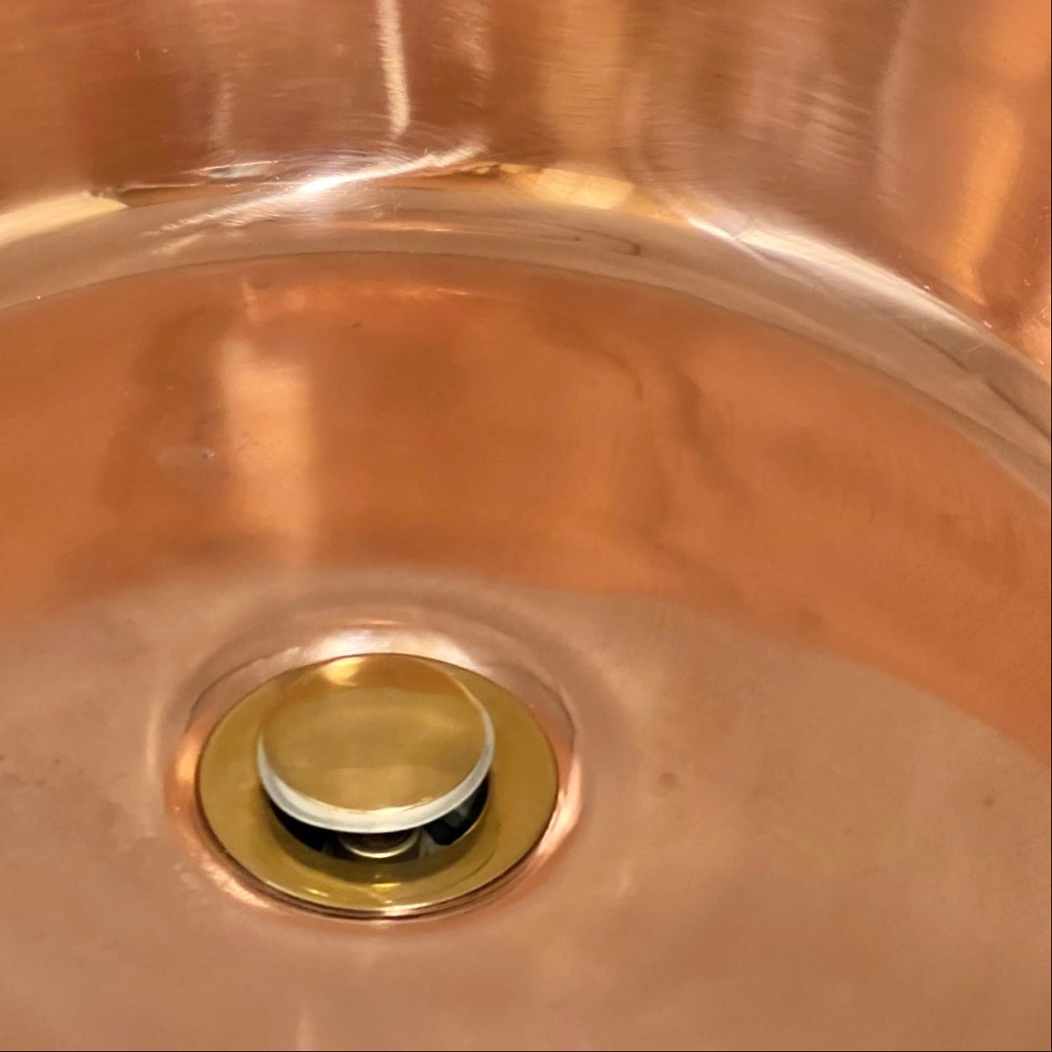 Close up of a copper basin sink on a white background