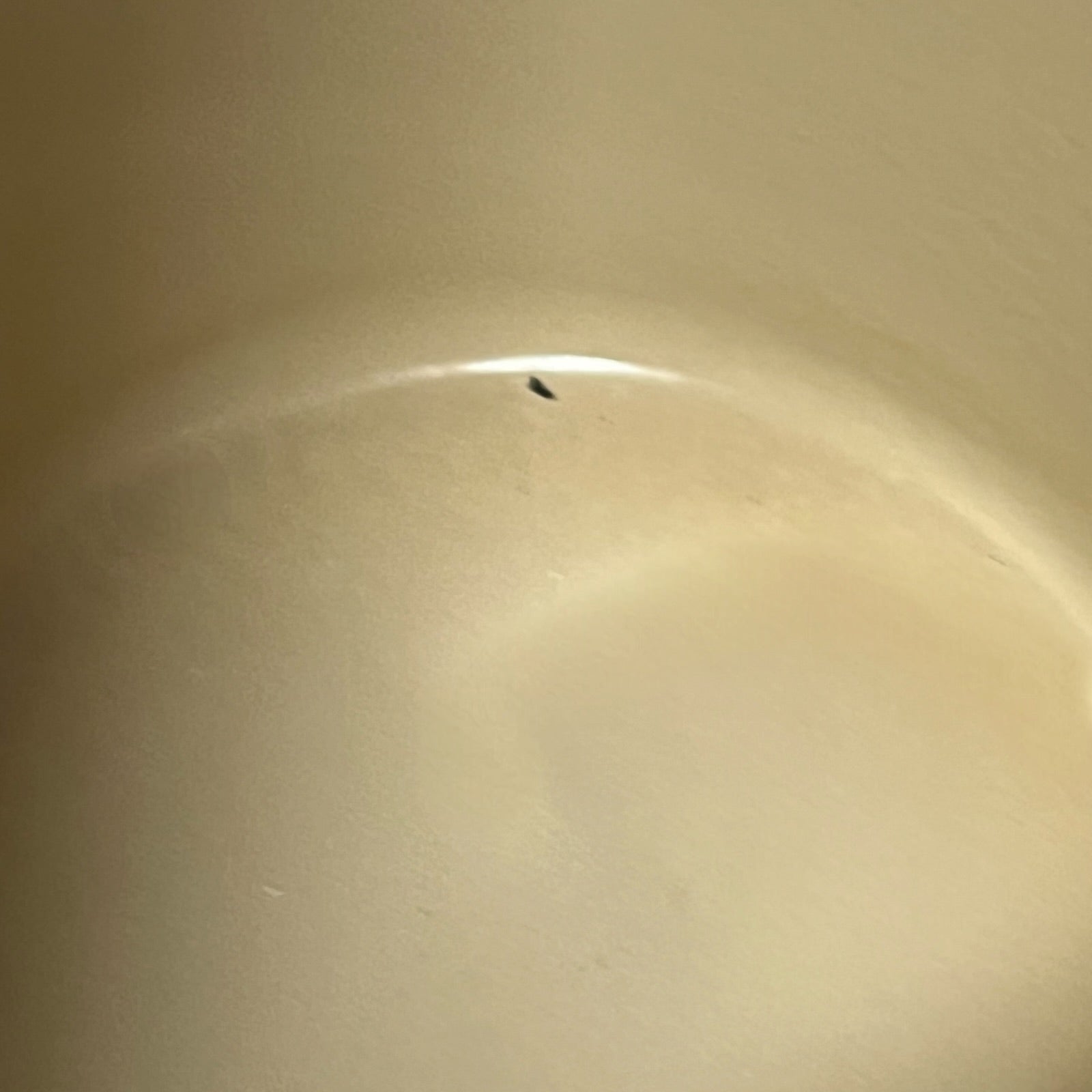 Close up of a rust coloured cast iron saucepan with lid on a white background
