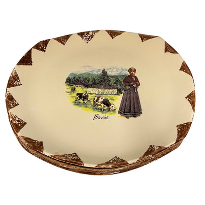 Decorative plate with a woman and cows illustration and 'Savoie' text on a beige background