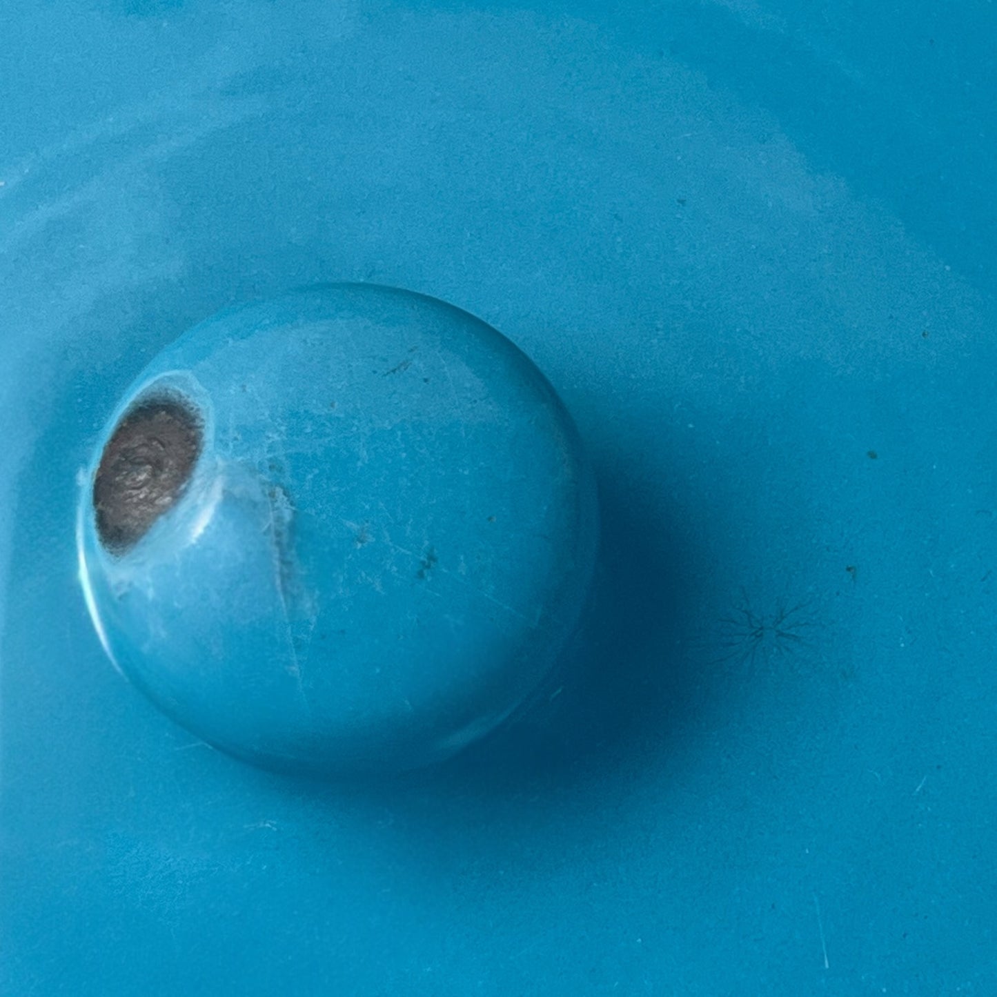 Close up of blue metal bucket with a wooden handle on a white background