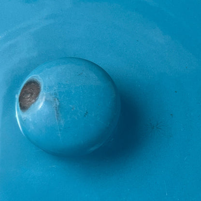 Close up of blue metal bucket with a wooden handle on a white background