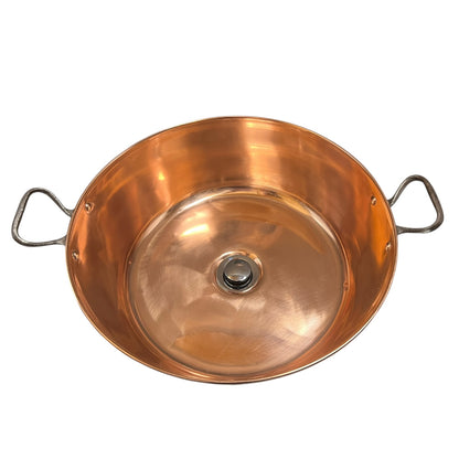 Copper bathroom sink up cycled from a French jam pan on a white background