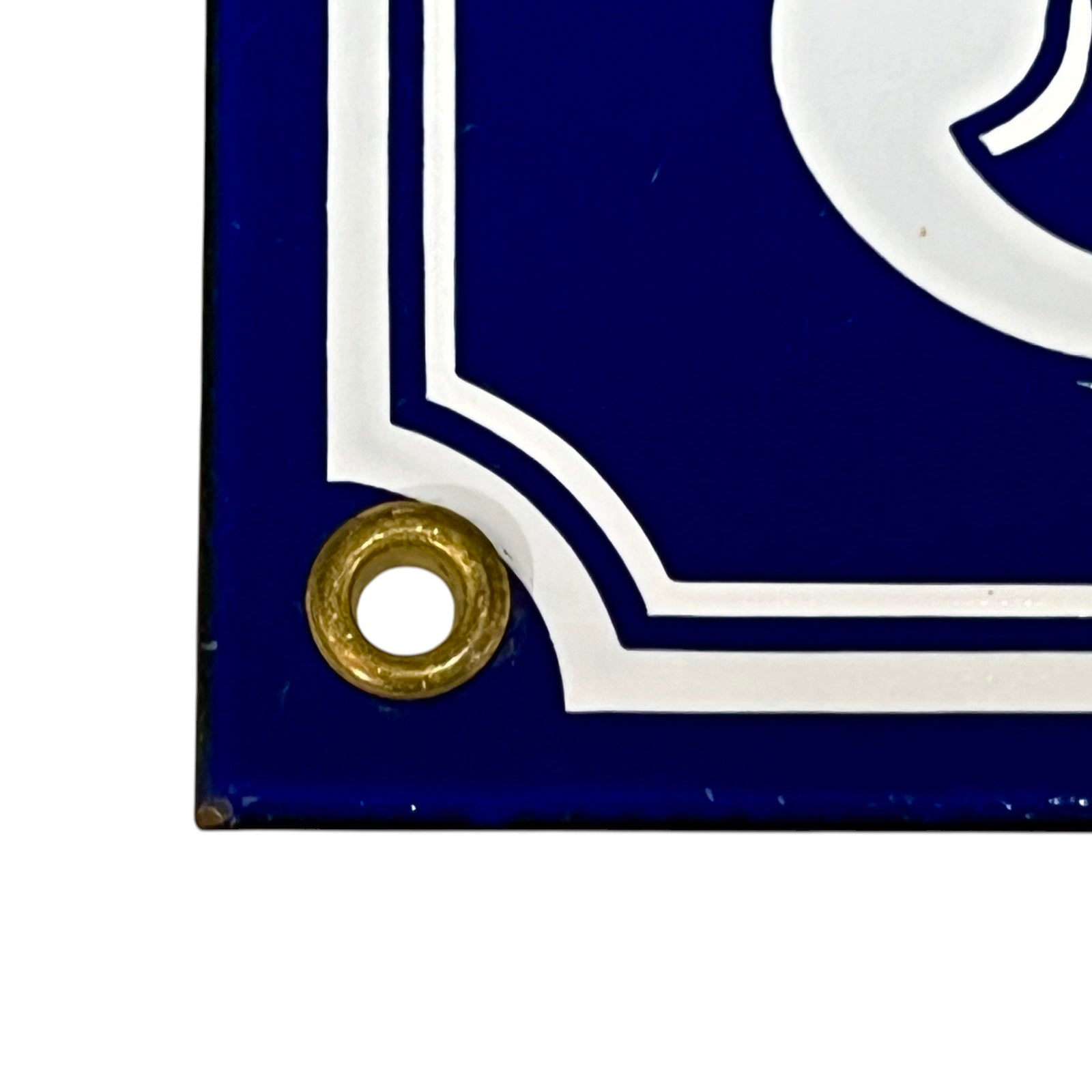 Close-up of a blue sign with a gold eyelet on a white background