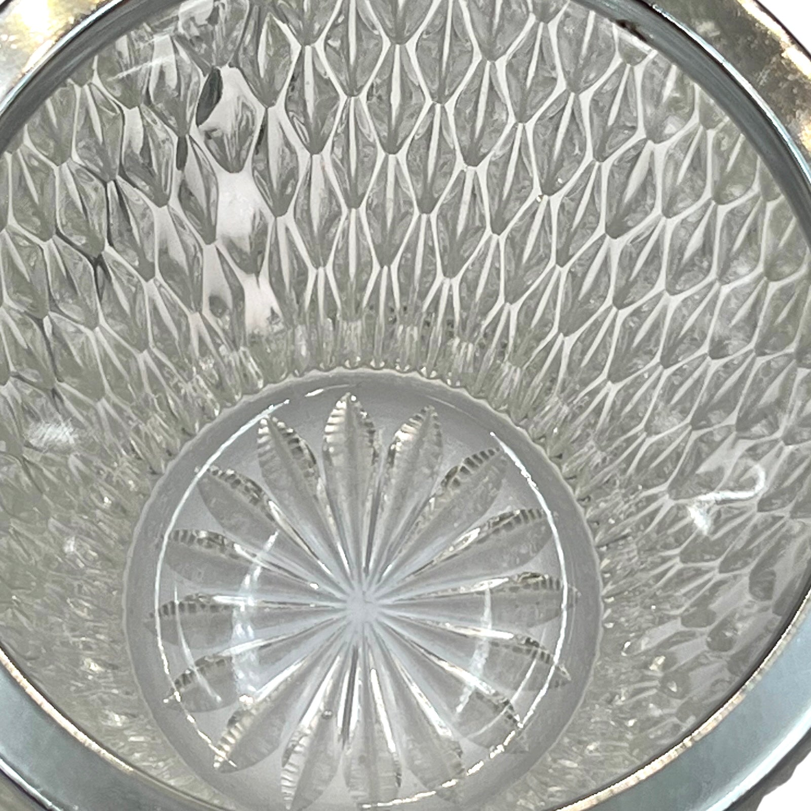 Close up of a French vintage glass ice bucket with a silver coloured collar and a handle on a white background 